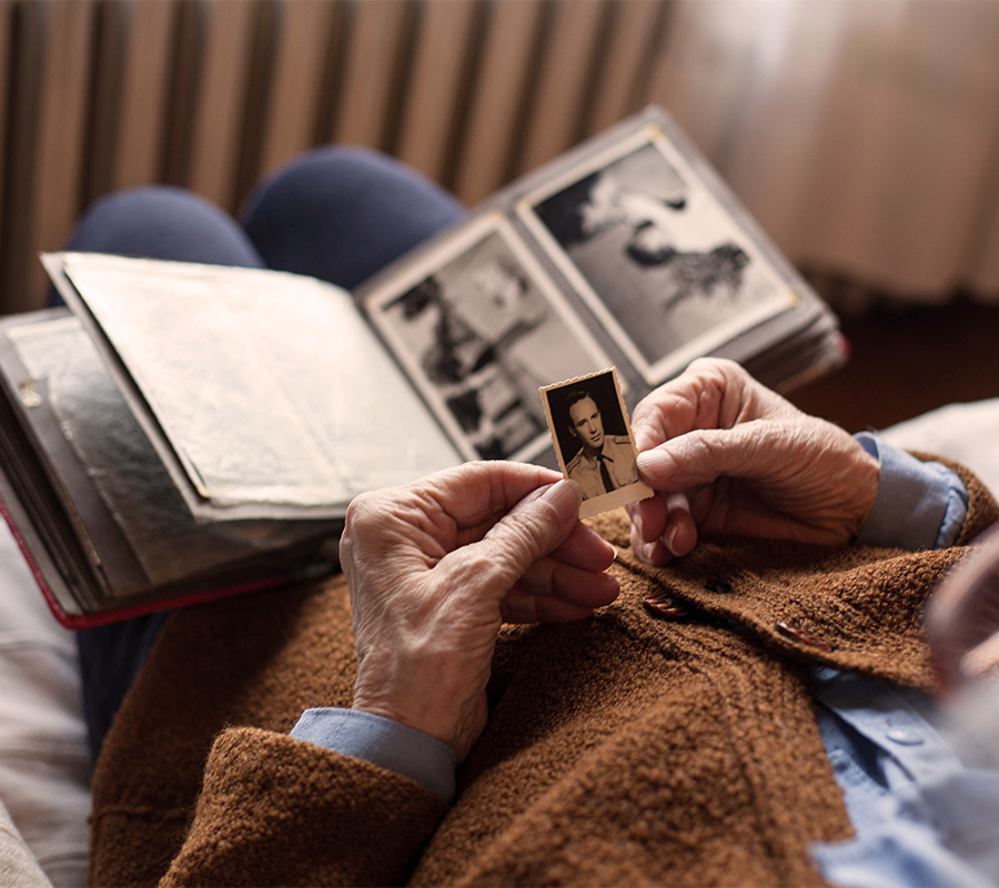Demenzbetreuung Düsseldorf Älterer Mann schaut sich ein altes Bild von sich an