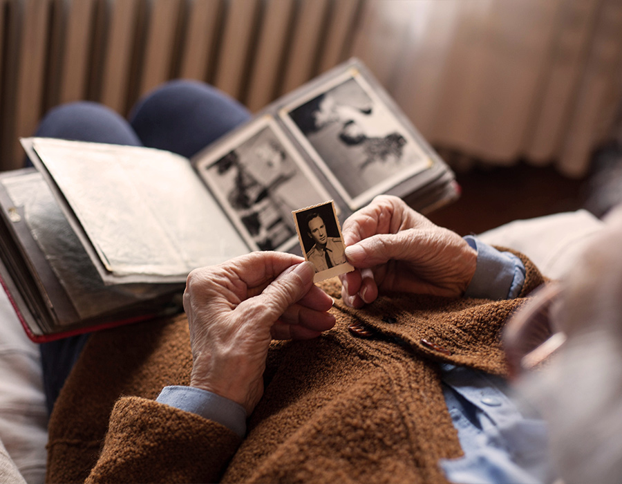 Älterer Mann schaut sich ein altes Bild von sich an
